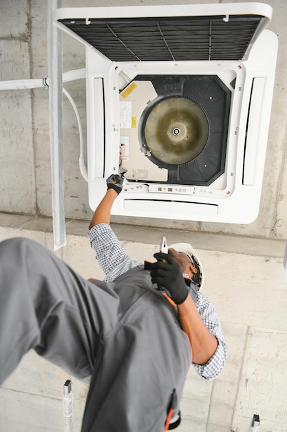 Photo professional repairman installing air conditioner in a room