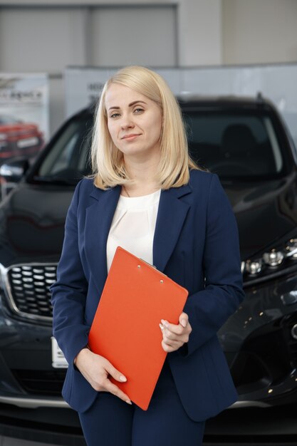 Professional salesperson selling cars at dealership to buyer