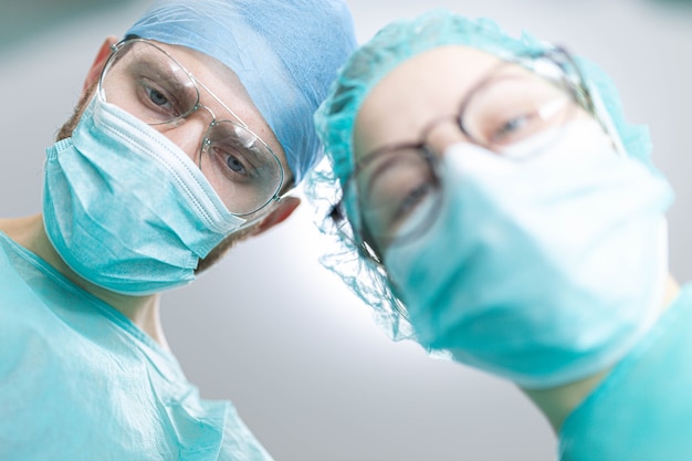 Professional surgeon with a young female assistant intern in a hospital operating room Shot from a