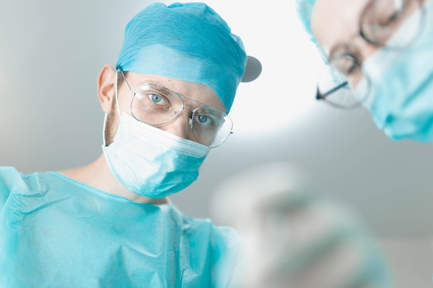 Professional surgeon with a young female assistant intern in a hospital operating room