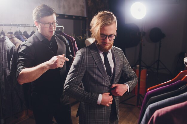 professional Tailor taking measurements for sewing suit at tailors shop