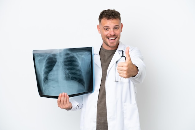 Professional traumatologist caucasian man isolated on white background with thumbs up because something good has happened