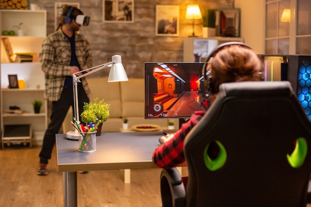 Photo professional video gamer female playing an online shooter game late night in the living room