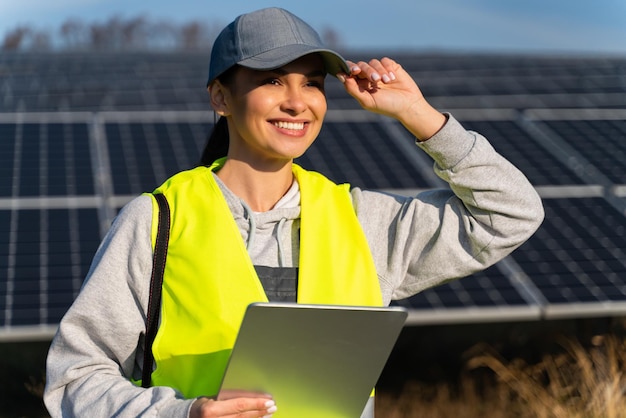 Professional woman engineer using tablet computer for maintenance on ecological green field with solar panels Photovoltaic power station Female worker