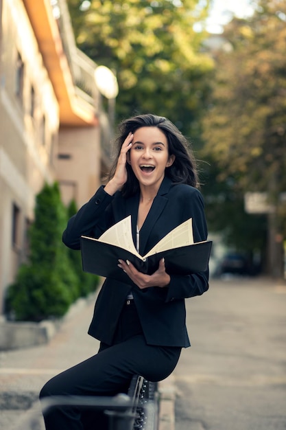 Professional woman in jacket working with documents at the street