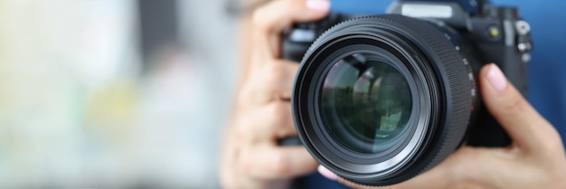 Professional woman photographer hold modern model of camera