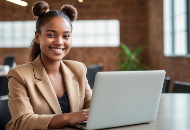 A professional woman works on her laptop in a modern office her beige blazer and warm smile denote