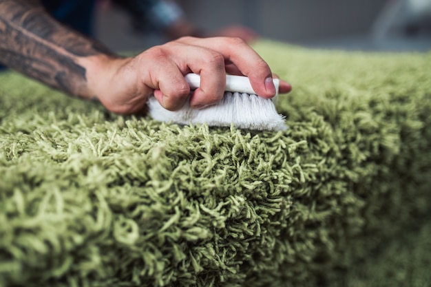 Professional worker doing his job at carpet washing service.