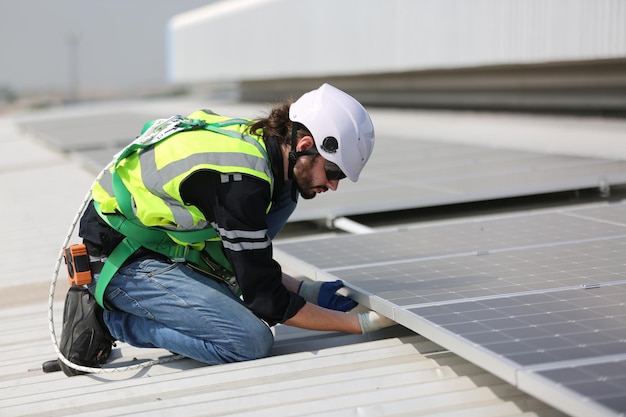 Professional worker installing solar panels on the roof of a house