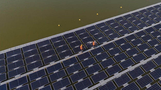 Photo professional workers clean and inspect solar panels on a floating buoy power plant with water