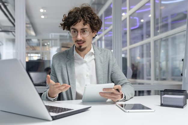 Professional young adult businessman concentrating at his workplace showing dedication and