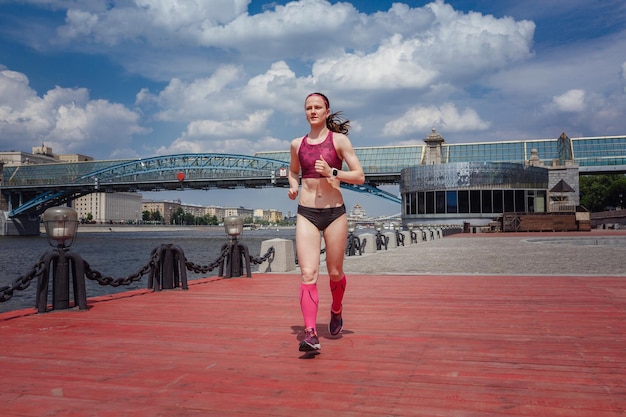 Professional young female runner player running in park for training personal speed and explosive force at holiday weekend The idea and concept of healthy lifestyle in a big city Moscow Gorky Park