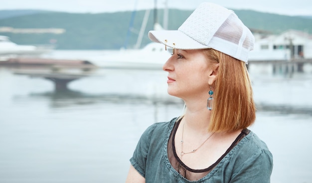 Profile of a beautiful mature woman in a cap enjoying the sea view summer time