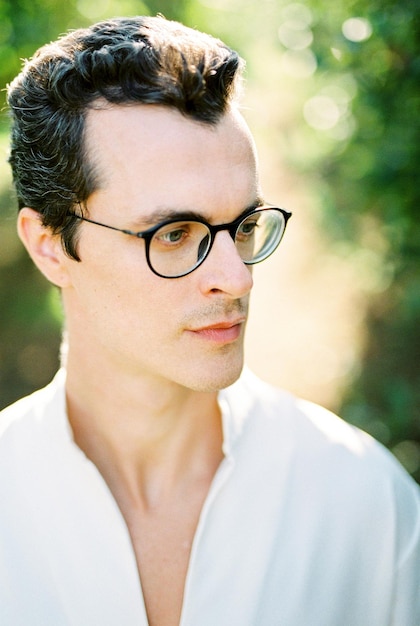 Profile of a man in a white shirt and glasses