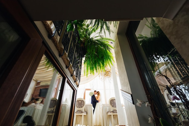 Profile of newlyweds in each other's arms in the restaurant hall