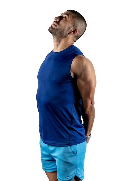 Profile portrait of a man in sportswear stretching his arms against a white background