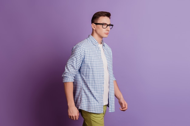 Profile portrait of successful confident freelancer guy walk look empty space on violet background