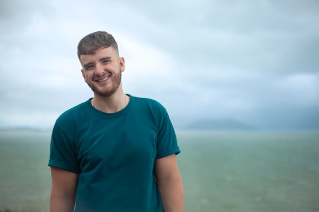 Profile side photo of handsome happy guy young man enjoying sea ocean view landscape looking into distance at summer day in tropical country at storm with cloudy sky breathing deep fresh air