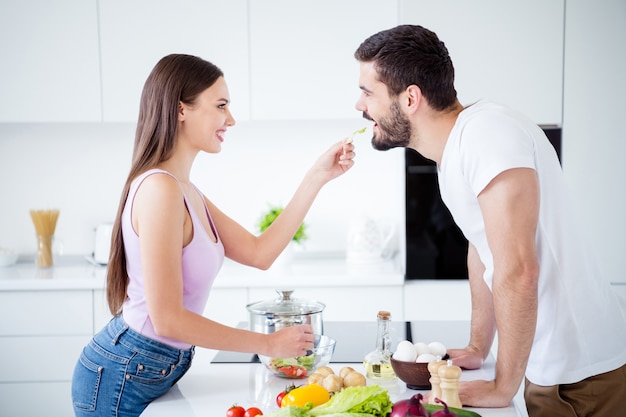 Profile side two people enjoy passionate bonding woman feed salad man