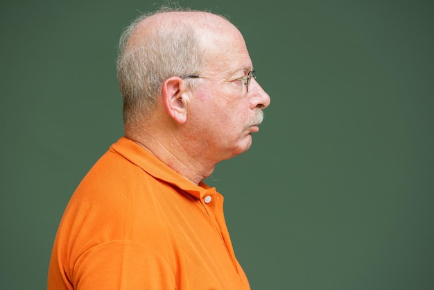 Profile view of grey haired senior man with mustache wearing eyeglasses