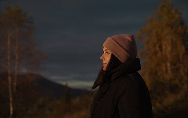 Profile view of a Happy woman watching sunset on mountain