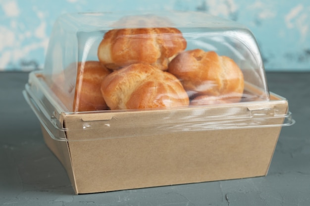 Profiteroles with cream in craft packaging