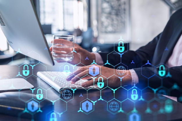 A programmer is typing a code on computer to protect a cyber security from hacker attacks and save clients confidential data Padlock Hologram icons over the typing hands Formal wear