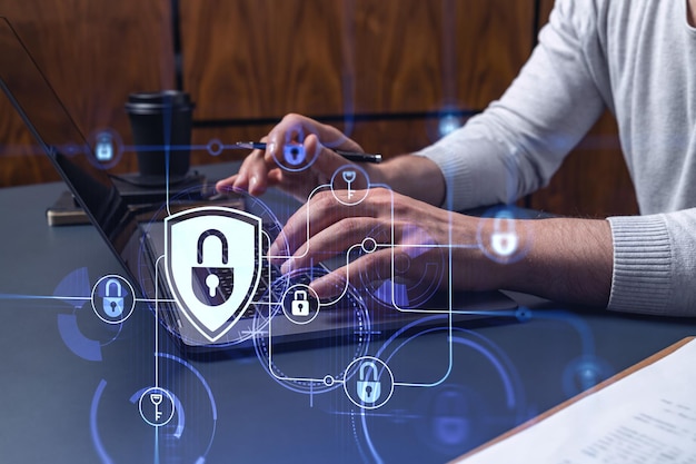 A programmer is typing a code on a keyboard to protect a cyber security from hacker attacks and save clients confidential data Padlock Hologram icons over the typing hands