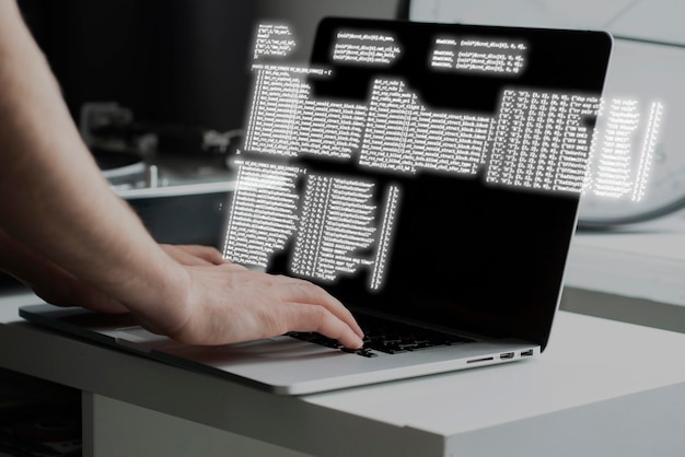 A programmer typing new software code on a laptop