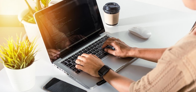 Programmer woman writing program HTML code sitting at workplace in office