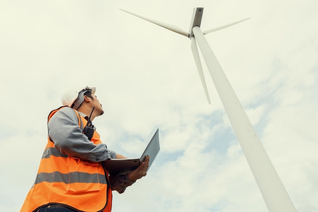 Photo progressive concept of engineer working in the wind farm atop of the mountain