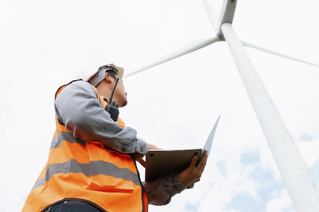 Photo progressive concept of engineer working in the wind farm atop of the mountain