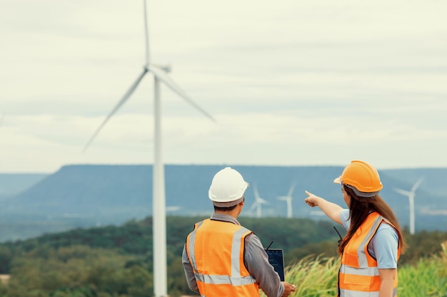 Progressive concept of engineers working in the wind farm atop of the mountain