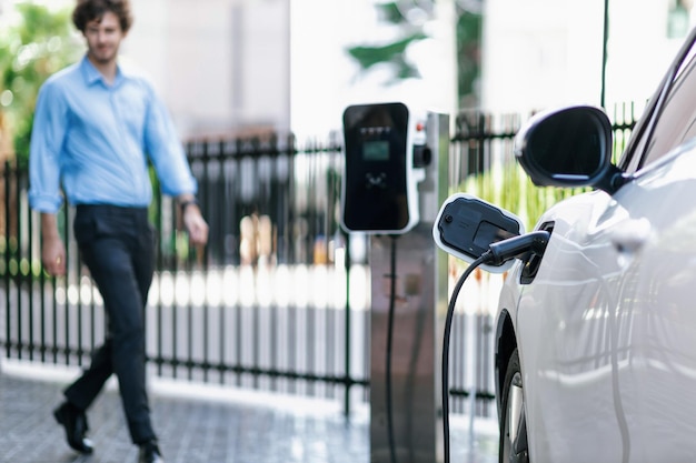 Photo progressive concept of focus ev car at charging station with blur man background