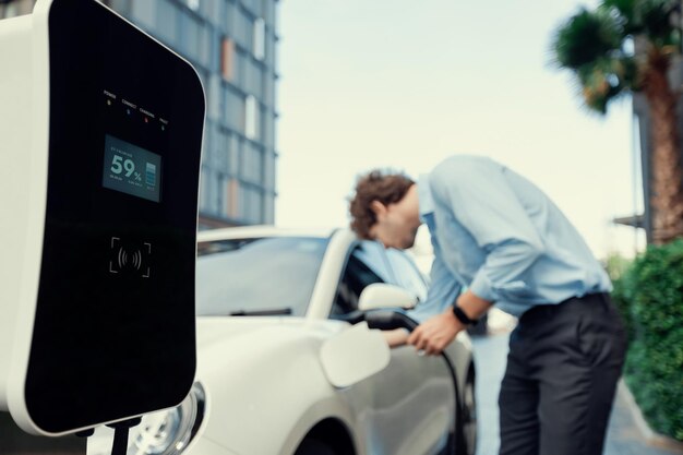 Progressive concept of focus EV car at charging station with blur man background