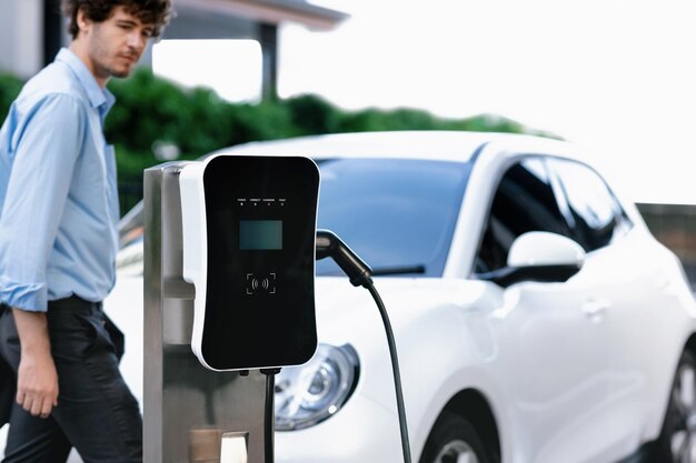 Progressive concept of focus EV car at charging station with blur man background