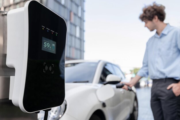 Progressive concept of focus EV car at charging station with blur man background