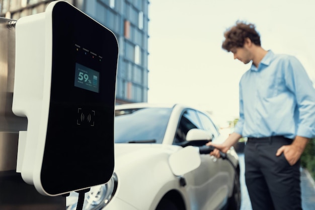 Progressive concept of focus EV car at charging station with blur man background