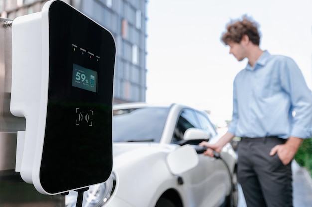 Progressive concept of focus EV car at charging station with blur man background