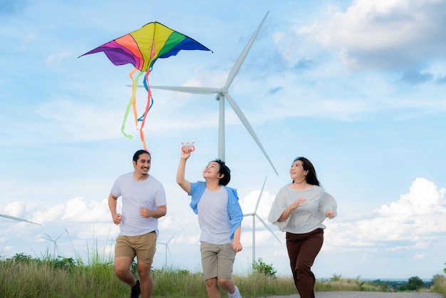 Progressive happy carefree family vacation concept flying kite with wind turbine