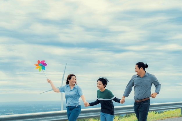 Progressive happy family enjoy their time at wind farm for green energy concept