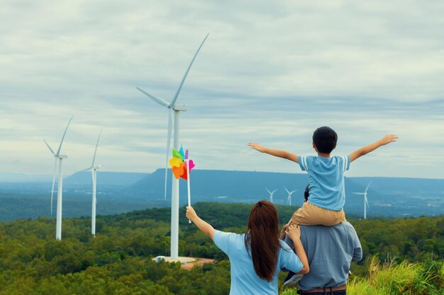 Progressive happy family enjoy their time at wind farm for green energy concept