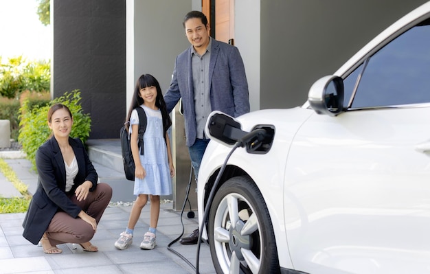 Progressive young parents and daughter living in a home with an electric car