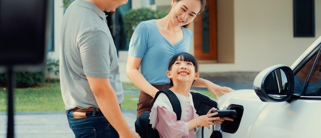 Progressive young parents and daughter living in a home with an electric car