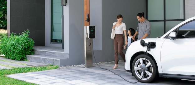 Progressive young parents and daughter living in a home with an electric car