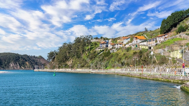 Promenade with picturesque lampposts and colorful houses by the sea in the village of Ribadesella Asturias