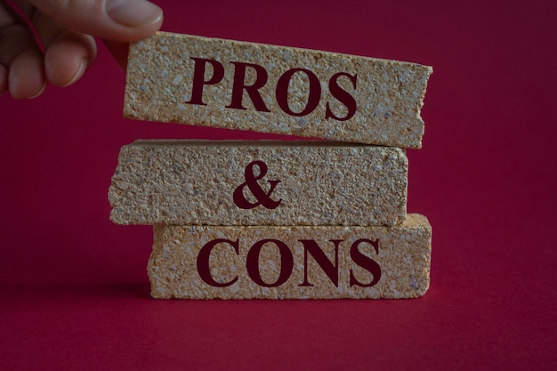 Pros and cons symbol Brick blocks with words Pros and cons Beautiful pink background