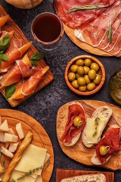 Prosciutto, cheese and olives on wooden boards