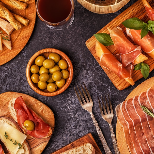 Prosciutto, cheese and olives on wooden boards