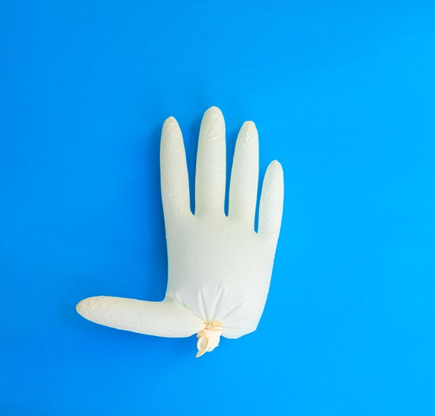 Photo protective inflated glove on blue background top view medical item balloon